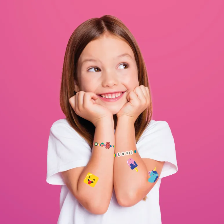 uśmiechnięta dziewczynka ze zmywalnymi tatuażami na rękach